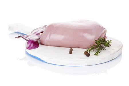 Fresh raw turkey meat on white wooden round chopping board isolated on white background. Culinary meat eating.の写真素材