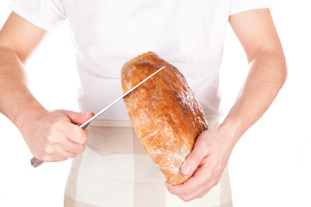 Baker holding and cutting fresh made bread isolated on white background. Baker and bakery.