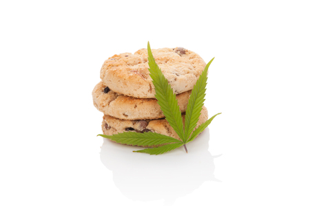 Chocolate cookies with marijuana leaf isolated on white background. Space cookies.の写真素材