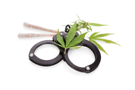 Marijuana joints, buds and leafs and handcuffs isolated on white background. Dangerous marijuana drug.の写真素材