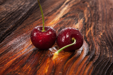 Fresh cherries with water drops on wooden table.の写真素材