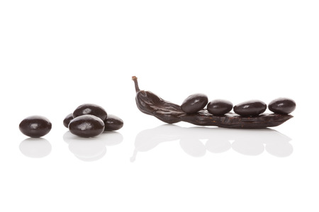 Carob pod and sweets isolated on white background. Healthy sweets eating.