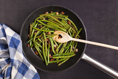 Healthy green legumes with bacon in pan from above. Healthy cooking concept.