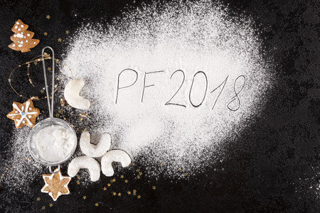 Holiday background. Christmas concept with gingerbreads, christmas cookies, sifter, spilled sugar from above.の写真素材