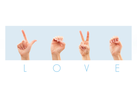 Female hand showing word love in American sign language. Isolated on blue background. の写真素材