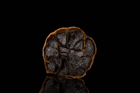 Black garlic on dark background. Culinary food ingredient.の写真素材