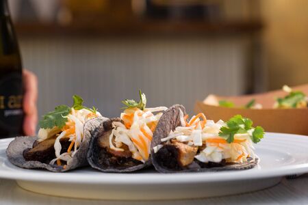 Carne asada Mexican style street food tacos with marinated meat, cilantro, onion and vegetable on white plate.の写真素材