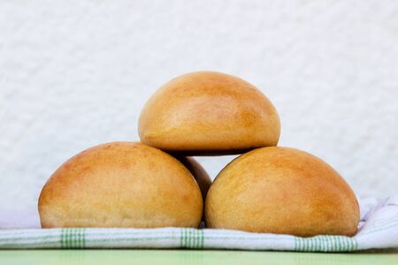 Group of fresh homemade burger buns on table outside on a sunny summer day. Barbeque concept.