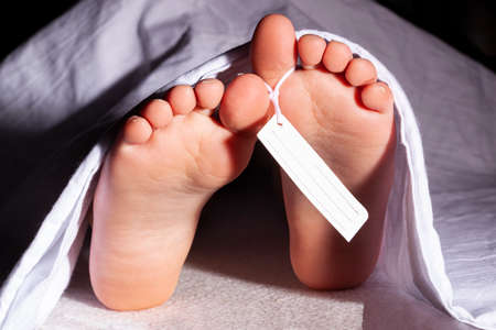 Covid19 victim in morgue. Dead body, corpse covered with white blanket.