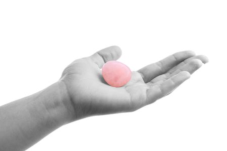 Hand offering rose quartz - hand in BW, emphasis on gemの写真素材