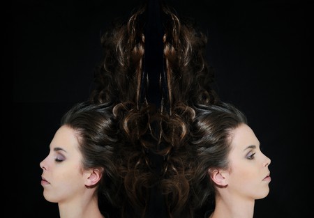 Portrait of young beautiful woman on black background with long hair (open and closed eyes)の写真素材