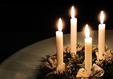 Christmas advent wreath with burning candles laid on table with black backgroundの写真素材