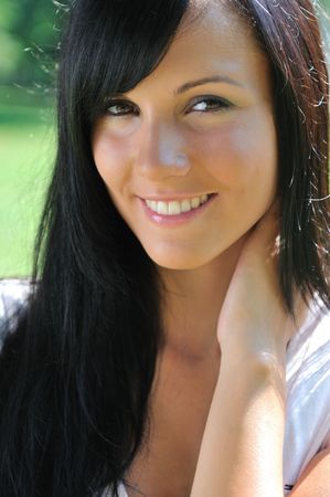 Portrait of young beautiful smiling woman with black hair - outdoorsの写真素材