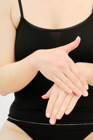 Woman in underwear applies cream on dry hands の写真素材