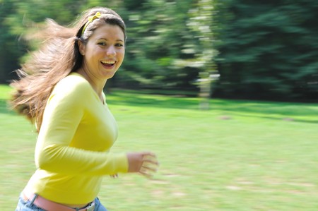 Panning shot of teenage girl running in parkの写真素材