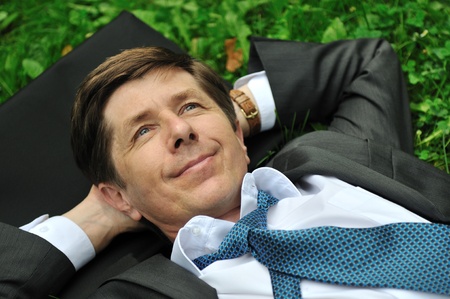 Senior people series - mature business man lying in grass and relaxingの写真素材