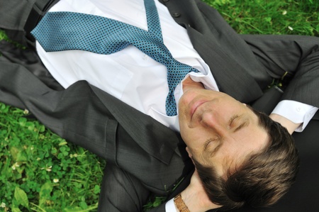 Senior people series - mature business man lying in grass and relaxingの写真素材
