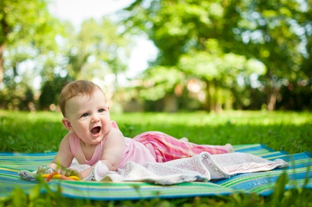 Portrait of baby - lying outdoors on rug and crying