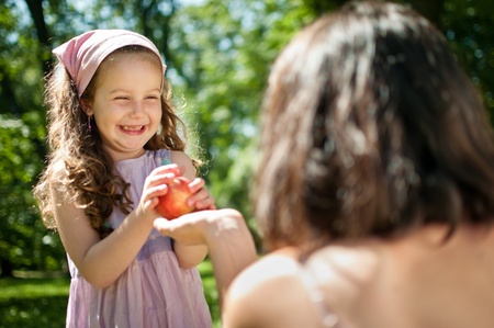 Offering apple - mother with childの写真素材
