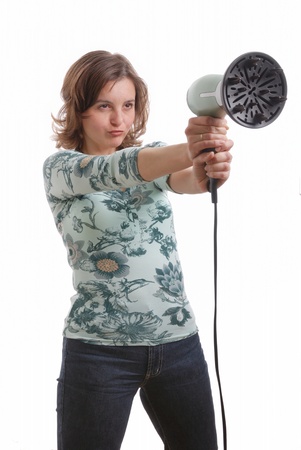 Young woman in casual dress shoots with hairdryer - isolated on white backgroundの写真素材