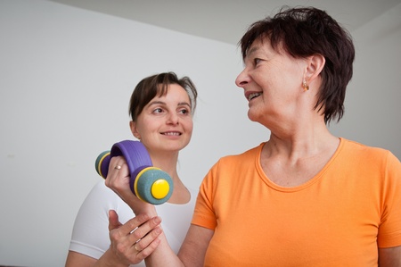 Senior woman exercising with trainerの写真素材