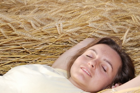 Young woman lies in golden grainの写真素材