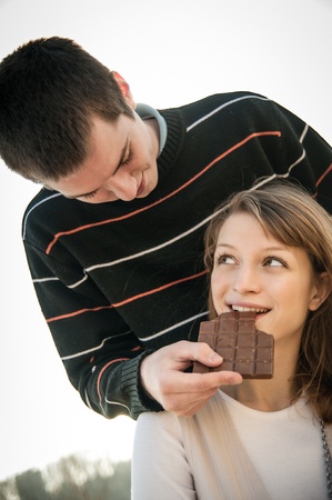 Young couple in locve eating chocolateの写真素材