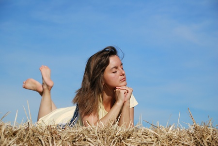 Young woman lying in hay