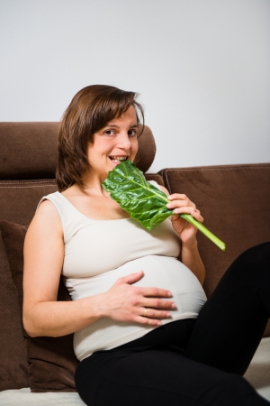 Pregnant woman eating spinachの写真素材