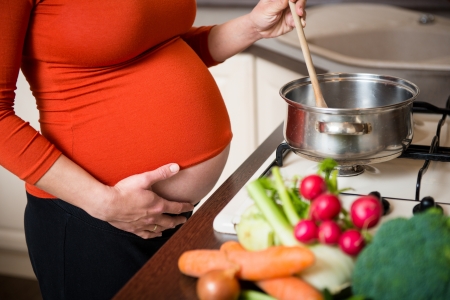 Pregnant woman cooking broccoliの写真素材