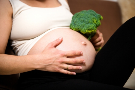 Detail of pregnant belly with broccoliの写真素材