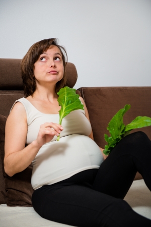 Pregnant woman eating spinachの写真素材