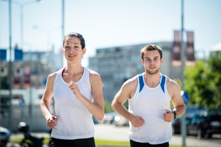 Young sport couple jogging together in city environmentの写真素材