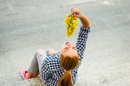 Young woman eating  grapesの写真素材