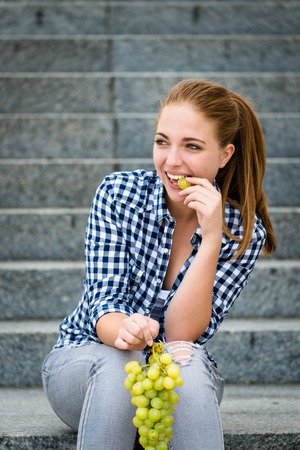 Young woman eating  grapesの写真素材