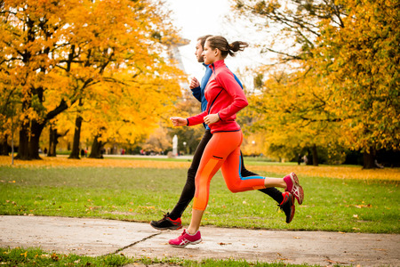 Couple jogging in autumn natureの写真素材
