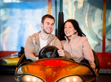 Young couple riding car in amusement parkの写真素材