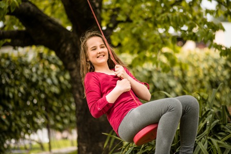 Girl swinging on seesawの写真素材