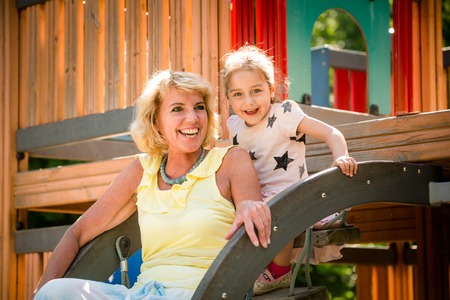 Exterior portrait of grandmother and her grandchild - outdoor in playgroundの写真素材