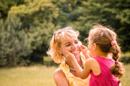 Authentic photo of grandmother and her grandchild playing together and having fun outdoor in natureの写真素材
