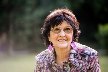 Portrait of smiling senior woman outside in natureの写真素材