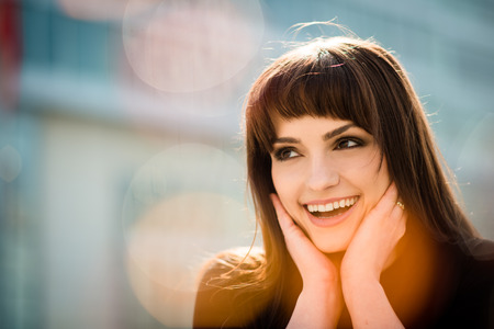 Portrait of smiling woman which is looking surprised with flare reflectionsの写真素材