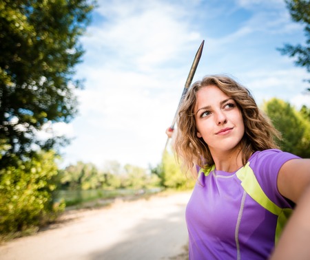 Focus - young woman throwing a javelinの写真素材