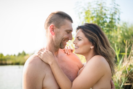 Smiling couple embracing while bathing in lakeの写真素材