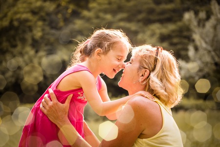 Grandchild and grandmother touching with nosesの写真素材