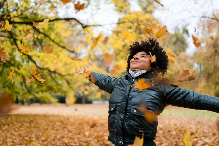 Smiling woman in park, arms outstretched.の写真素材