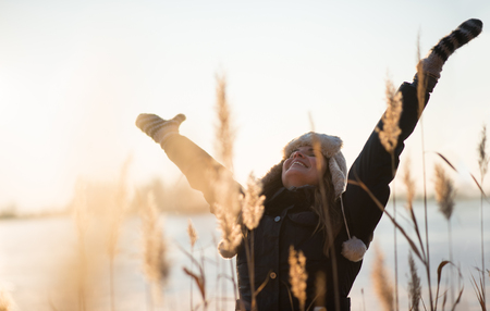 Joyful woman raising her arms upの写真素材