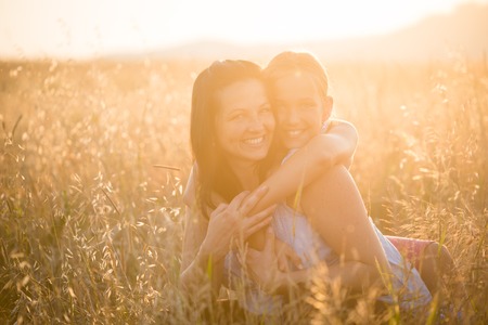 Affectionate young daughter hugging her motherの写真素材