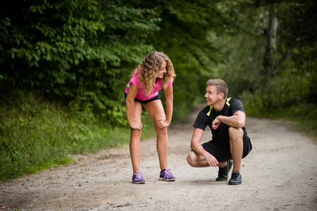 Joggers resting on gravel trail after overtrainingの写真素材