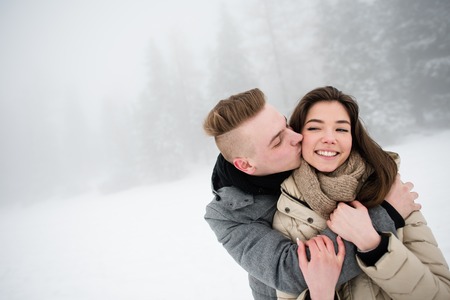 Handsome young man kissing her girlfriend from behind